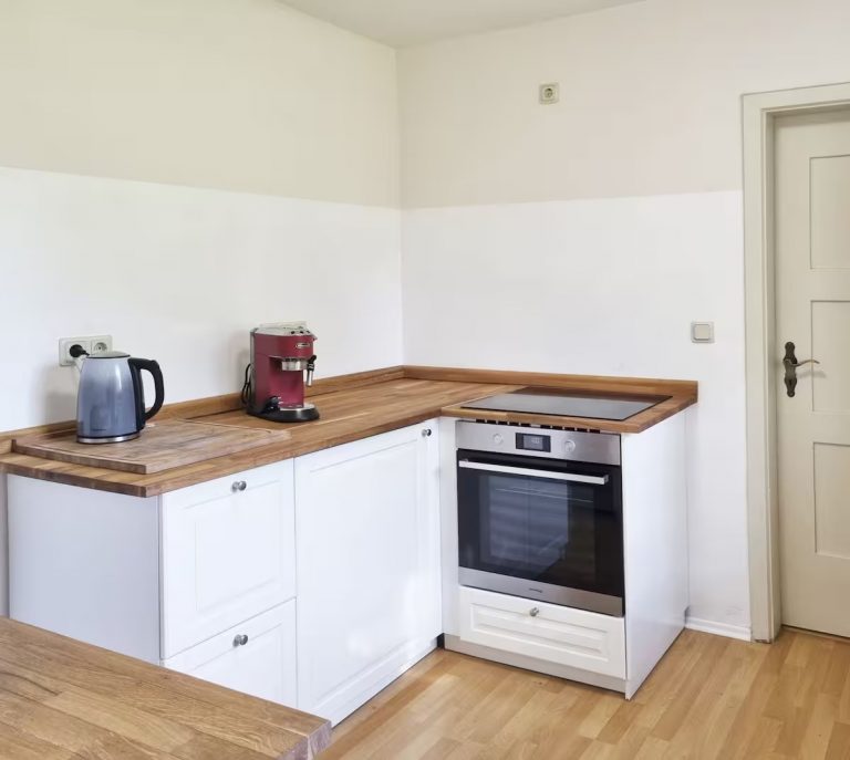 Blick in die Küche mit Herd/Kochfeld, Kaffeemaschine, Wasserkocher und Espressomaschine.