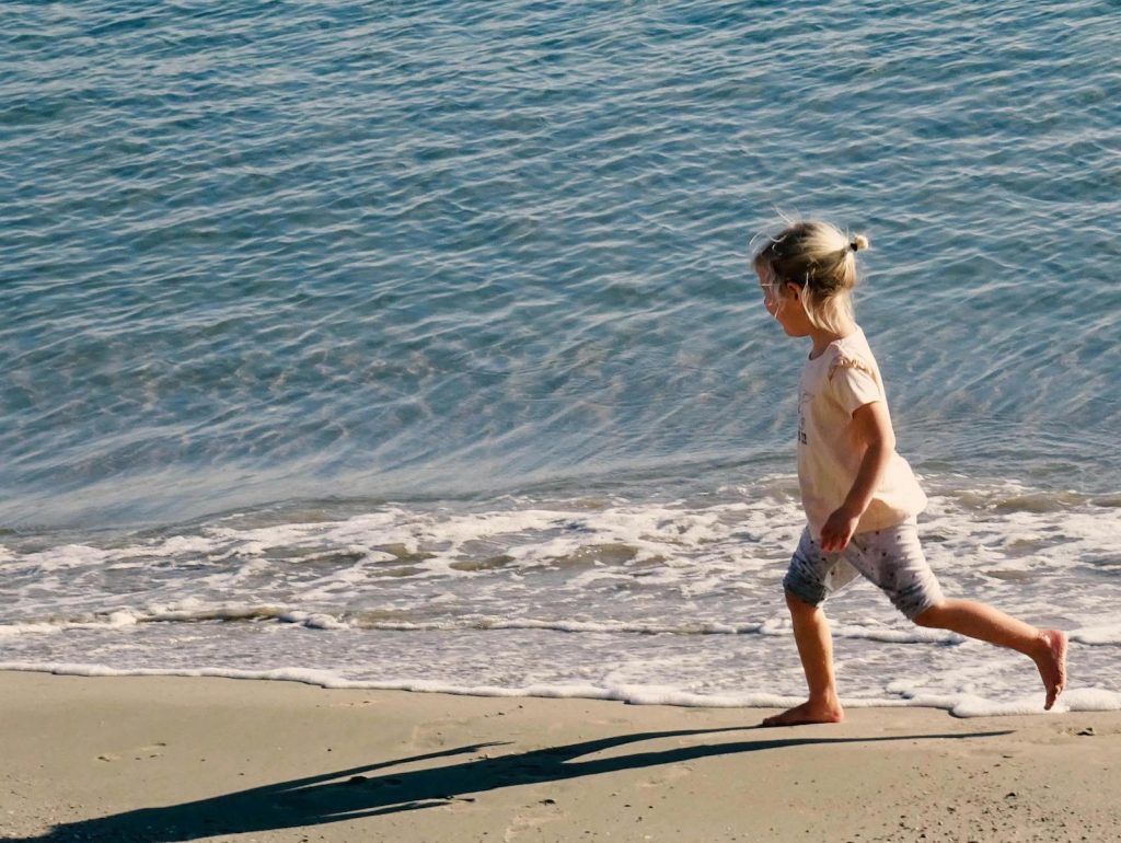 Kind läuft am Strand – familienfreundliche Ausflüge an die Ostsee